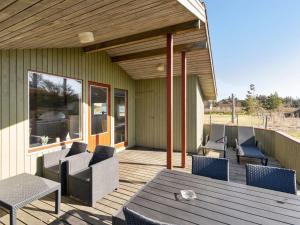 a patio with chairs and a table on a deck at Holiday Home Frille - 200m from the sea by Interhome in Blåvand