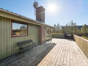 a wooden deck with a bench on a house at Holiday Home Frille - 200m from the sea by Interhome in Blåvand +15 photos