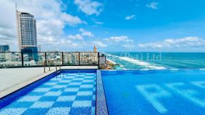 a swimming pool on the roof of a building overlooking the ocean at Beachfront Colombo 03 Bed Apartment in Colombo