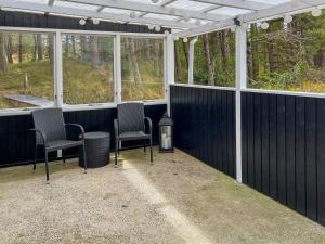 a screened in porch with chairs and windows at Holiday Home Gertruda - 220m from the sea by Interhome in Vester Sømarken