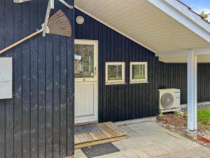 a black house with a door and a fan at Holiday Home Gertruda - 220m from the sea by Interhome in Vester Sømarken +20 photos