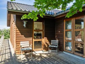 a wooden house with two chairs and a porch at Holiday Home Nantje - 560m to the inlet by Interhome in Jægerspris