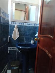 a bathroom with a blue sink and a mirror at Mi casa, Tu casa in Huacho
