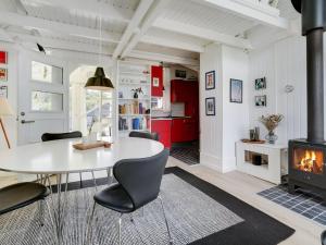een woonkamer met een tafel, stoelen en een open haard bij Holiday Home Solfrid - 150m from the sea by Interhome in Esbjerg +25 foto's
