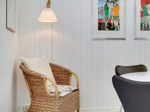 een rieten stoel met een tafel en een lamp bij Holiday Home Solfrid - 150m from the sea by Interhome in Esbjerg
