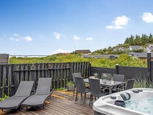 een terras met een tafel en stoelen en een bad bij Holiday Home Solfrid - 150m from the sea by Interhome in Esbjerg