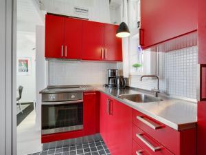 een rode keuken met een wastafel en rode kasten bij Holiday Home Solfrid - 150m from the sea by Interhome in Esbjerg