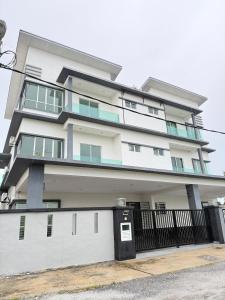 a large white building with a black fence at Sekinchan 2008 Homestay KaraokeBBQ 20pax 三层简约风名宿 in Sekincan
