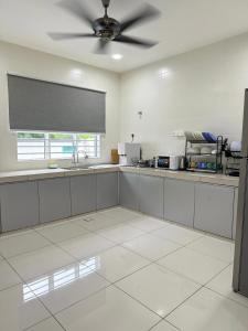 a large kitchen with a ceiling fan in a room at Sekinchan 2008 Homestay KaraokeBBQ 20pax 三层简约风名宿 in Sekincan