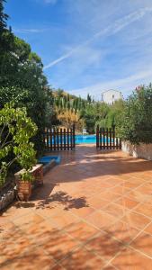 a patio with a fence and a swimming pool at CASA RURAL SANTA ELENA in Cazalla de la Sierra