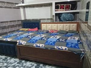 a bed with a blue and white quilt on it at saryu home stay in Ayodhya