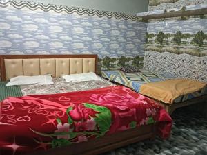 a bedroom with two beds and a wall with flowers at saryu home stay in Ayodhya