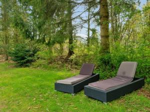 two chairs sitting in the grass in a yard at Holiday Home Kierstine - 7km from the sea by Interhome in Ebeltoft