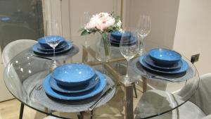 un tavolo di vetro con piatti blu e bicchieri da vino di Hidden Gem of City Center a Manchester