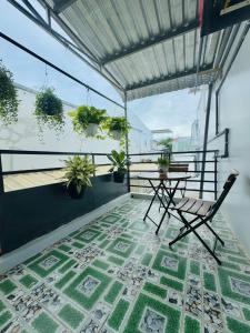 a table and chair on a balcony with plants at Homestay Kim Mỹ in Ấp Rạch Mẹo