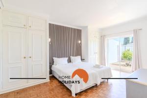a bedroom with a bed with a home holidays sign on it at #336 Vila Sol by Home Holidays in Sesmarias