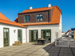 ロッケンにあるHoliday Home Gerd - 400m from the sea by Interhomeのオレンジ色の屋根の白い家、パティオ