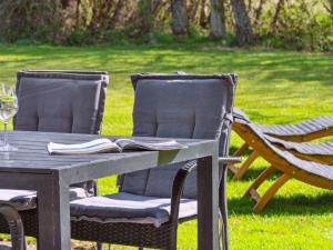 - une table en bois avec deux chaises et un livre dans l'établissement Holiday Home Amiira - 500m from the sea by Interhome, à Gilleleje