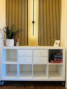 a white desk with a potted plant on top at charmantes Apartment bei Hamburg - Ruhe, Komfort & kostenloses Parken in Rellingen +36 photos