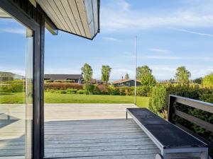 a wooden porch with a bench on a deck at Holiday Home Manfred - 250m from the sea by Interhome in Rønde