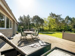 a wooden deck with a table and chairs on it at Holiday Home Rohan - 700m from the sea by Interhome in Rødby