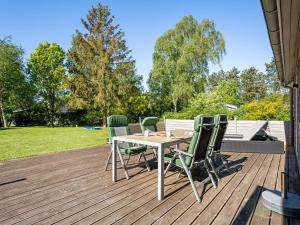 a wooden deck with a table and chairs on it at Holiday Home Rohan - 700m from the sea by Interhome in Rødby +19 photos