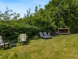 a group of chairs sitting in the grass in a yard at Holiday Home Fenna - 30km from the sea by Interhome in Toftlund