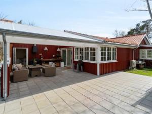 ein rotes Haus mit einer Terrasse davor in der Unterkunft Holiday Home Tarje - 320m from the sea by Interhome in Rønne