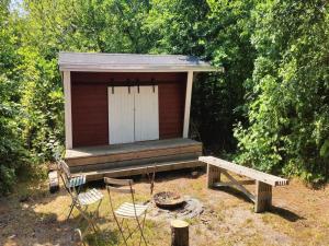 ein kleines Nebengebäude mit einer Bank und einer Veranda in der Unterkunft Holiday Home Tarje - 320m from the sea by Interhome in Rønne