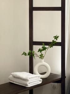 a white vase sitting on a wooden shelf with a plant at Little Chái Nho - The Flow in Da Lat