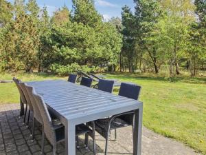 a blue table and chairs in a park at Holiday Home Alina - 1km from the sea by Interhome in Mølby