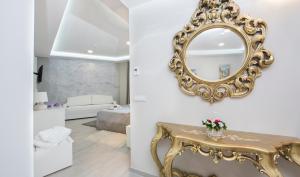 a living room with a mirror and a table at Boutique Hotel Melissa in Poreč