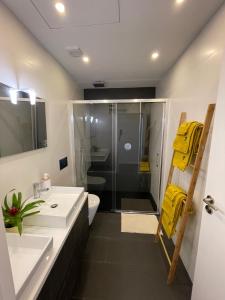 a bathroom with a white sink and a shower at Living Viana do Castelo in Viana do Castelo +27 photos