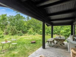 a wooden deck with a table and a picnic table at Holiday Home Juho - 700m from the sea by Interhome in Læsø +10 photos