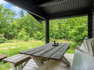 a wooden picnic table on a deck with a bench at Holiday Home Juho - 700m from the sea by Interhome in Læsø