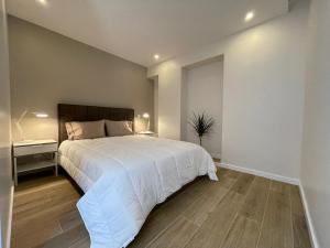 a bedroom with a large white bed and a desk at Living Viana do Castelo in Viana do Castelo