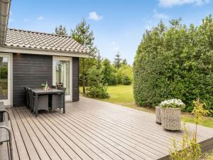 a wooden deck with a table on a house at Holiday Home Lissi - 3-5km from the sea by Interhome in Brovst +18 photos