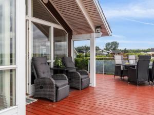 een afgeschermde veranda met stoelen en een tafel bij Holiday Home Annrike - 175m to the inlet by Interhome in Jægerspris +19 foto's