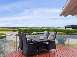 een terras met een tafel en stoelen op een dek bij Holiday Home Annrike - 175m to the inlet by Interhome in Jægerspris