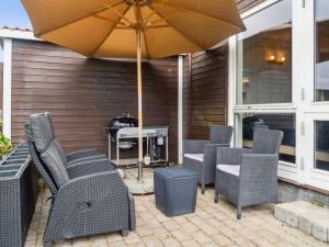 een groep stoelen en een parasol op een patio bij Holiday Home Annrike - 175m to the inlet by Interhome in Jægerspris