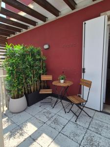 a table and two chairs next to a red wall at Residenza Elena227 in Vicenza +10 photos