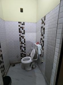 y baño con aseo en una pared de azulejos. en Hotel Crystal Blues, en Mathura