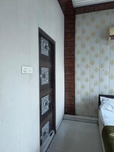 Habitación con puerta en habitación con cama en Hotel Crystal Blues, en Mathura