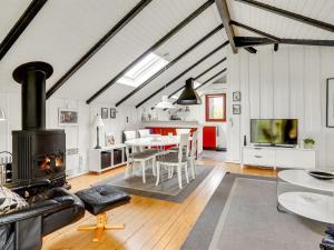 una sala de estar con una mesa y una chimenea en Holiday Home Magnus - 250m to the fjord by Interhome, en Esbjerg