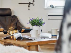 - une table basse avec un livre et des fleurs dans l'établissement Holiday Home Jenvold - 950m from the sea by Interhome, à Dronningmølle