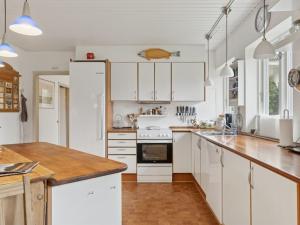 une cuisine avec des armoires blanches et un comptoir en bois dans l'établissement Holiday Home Jenvold - 950m from the sea by Interhome, à Dronningmølle
