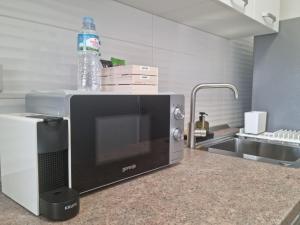 a microwave sitting on top of a kitchen counter at Studio Nova - Minimalist and Elegant with Parking in Bucharest +10 photos