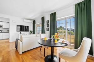 a living room with a table and a couch at MBird 19 Estoril Apartments in Estoril