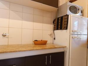a kitchen with a white refrigerator and a microwave at Hospedaje Cabañas Costa Tilcara in Tilcara