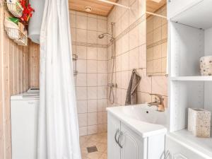 a bathroom with a shower curtain and a sink at Holiday Home Thorir - 500m from the sea by Interhome in Dannemare +8 photos